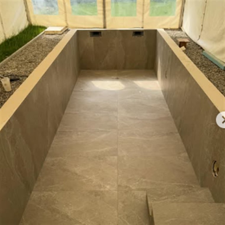 Schwimmbecken mit großformatigen Platten an Wänden, Boden und Treppe